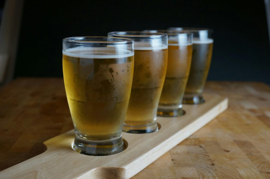 4 glasses of beer being served