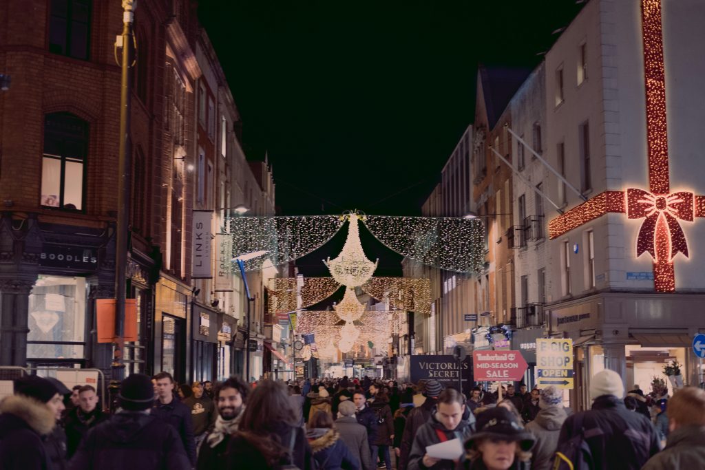 people gathered in a shopping strip during Christmas time at night