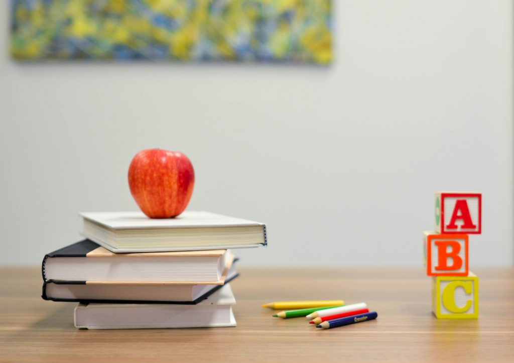 Apple on top of school books