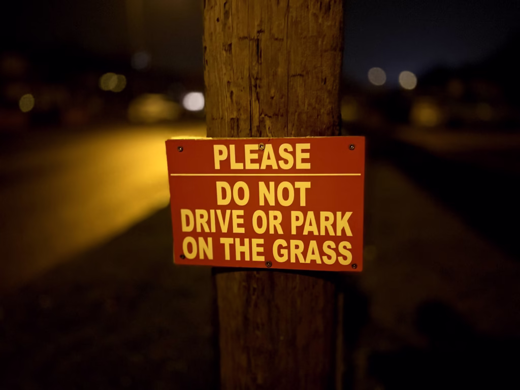 Event parking sign that says “please do not drive or park on the grass”
