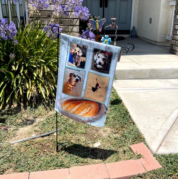 a garden flag with photos of dogs and bread.