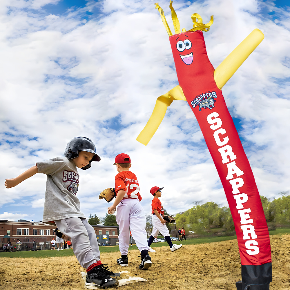 Custom Scrappers inflatable tube man on a baseball field with kids playing nearby
