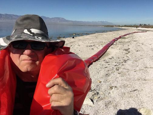Why you should be using Tube Men to Advertise 3 A man dragging a long red balloon on a beach.