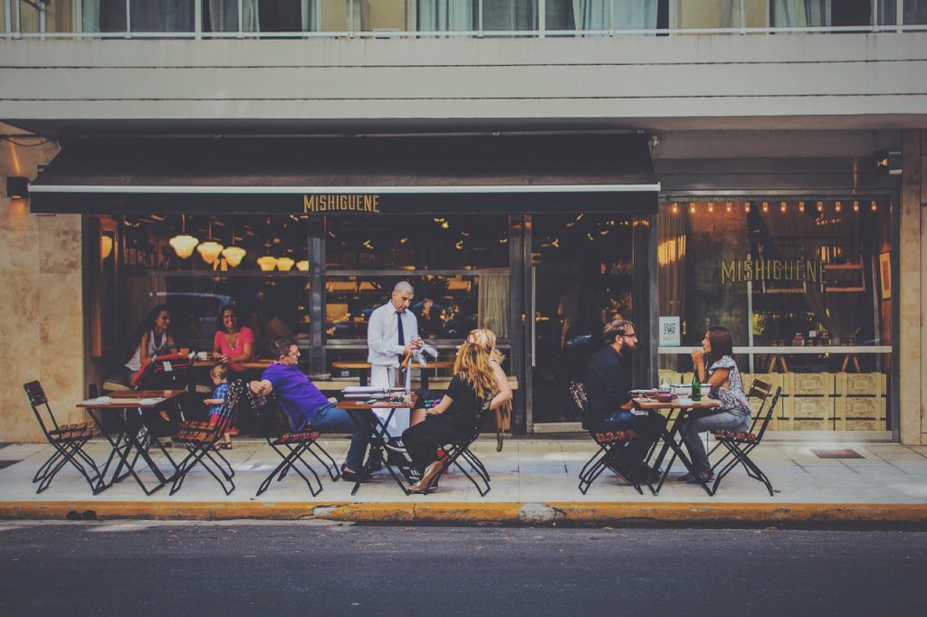 Waiter serving customers outside restaurant