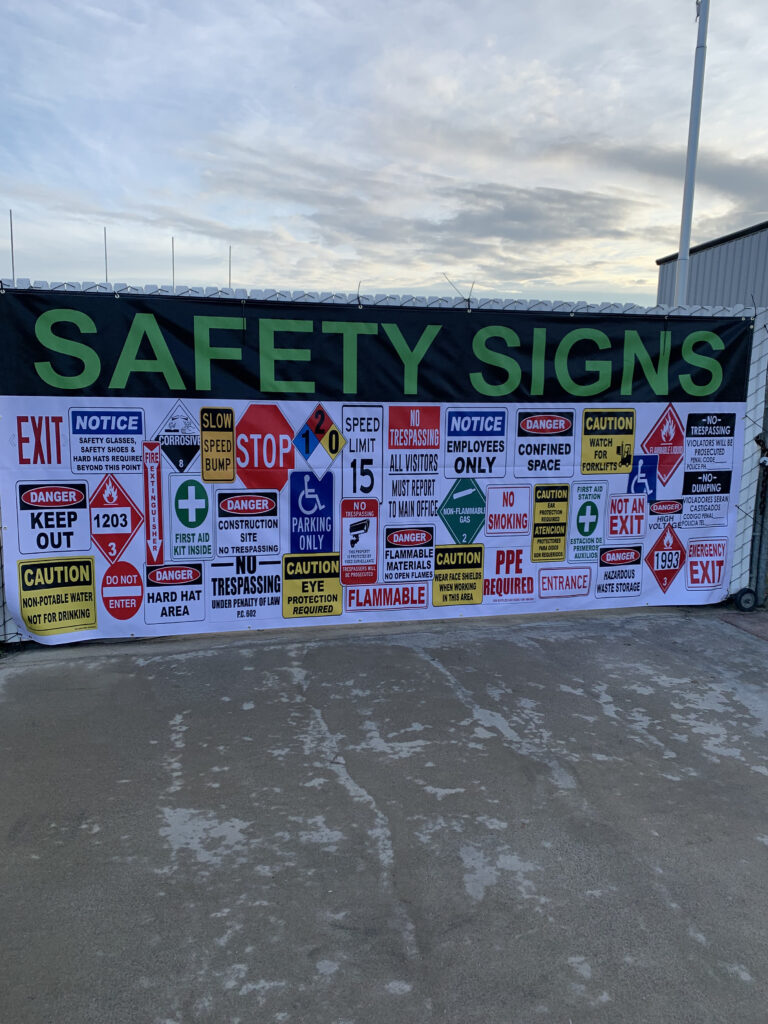 Safety signs displayed across a fence