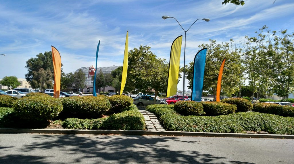 six feather flags near parking lot