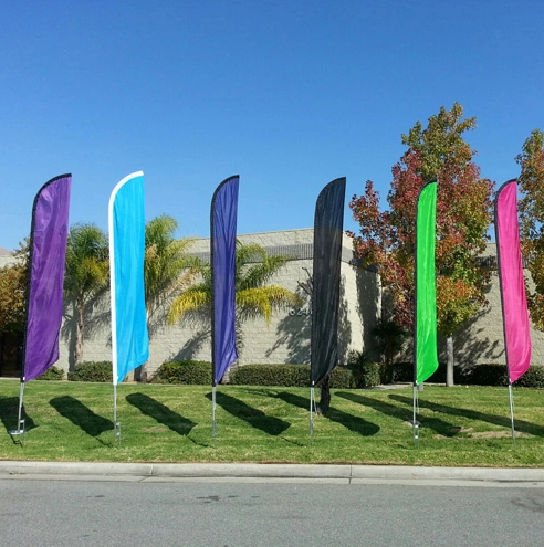 six colorful feather flags on grass