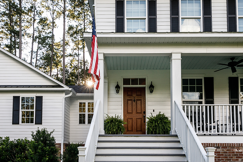 a white house with an american flag hanging outside