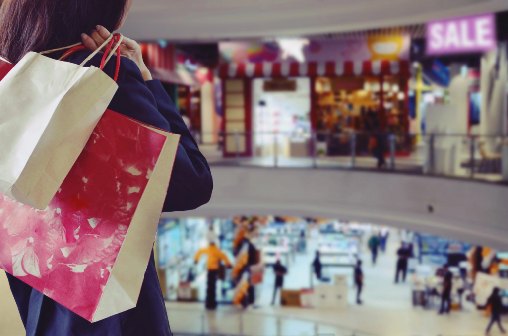a woman holding shopping bags in a mall