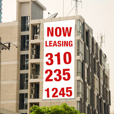 A white and red personalized vinyl banner on the side of a building